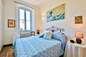 a bedroom with a blue bed and a table at IL FARO by KlabHouse in Santa Margherita Ligure