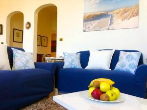 a blue couch with a plate of fruit on a table at IL FARO by KlabHouse in Santa Margherita Ligure