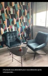 - un salon avec deux chaises et une table dans l'établissement Studio centre-ville, à Montceau-les-Mines