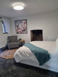 1 dormitorio con 1 cama, 1 silla y chimenea en Bridgewater Cottage, en Bridgewater