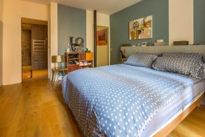 a bedroom with a bed with a blue and white comforter at LOFT 11e près Canal St-Martin - Chambre climatisée SDB privée in Paris