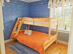 een slaapkamer met een stapelbed met een oranje sprei bij Hus nära havet in Bergkvara