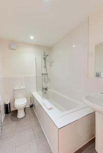 a bathroom with a tub and a toilet and a sink at Duke Street Apartment Hotel Liverpool City Centre in Liverpool