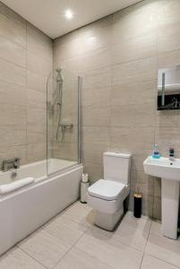 a bathroom with a toilet and a tub and a sink at Duke Street Apartment Hotel Liverpool City Centre in Liverpool