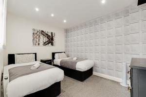 2 camas en una habitación con paredes blancas en Duke Street Apartment Hotel Liverpool City Centre en Liverpool
