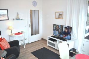 een woonkamer met een flatscreen-tv op een tafel bij Carpe Diem Ferienwohnung Nr 187 Meerblick in Niendorf