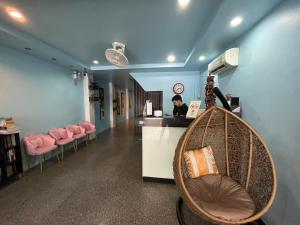 a hair salon with pink chairs and a woman at a counter at Armoni Patong Beach Hotel in Patong Beach