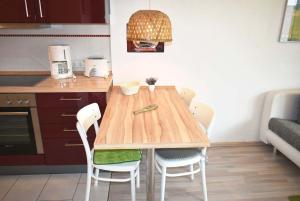 - une cuisine avec une table et des chaises en bois dans l'établissement Carpe Diem Ferienwohnung Nr 97, à Niendorf