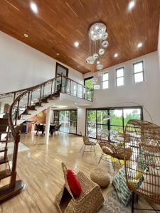 a living room with a spiral staircase in a house at RNR Villas and Farm Resort in Morong