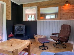 een woonkamer met een tafel, een stoel en een fornuis bij Cozy Zweeds huis met openhaard en grote tuin in Ramsele
