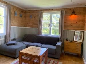 Cozy Zweeds huis met openhaard en grote tuin في Ramsele: غرفة معيشة مع أريكة وطاولة