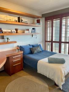 a bedroom with a blue bed and a desk at a V I E W or 2 in Cape Town
