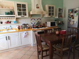 a kitchen with a table with chairs and a microwave at Stanza Il melo in fiore in Ferrara