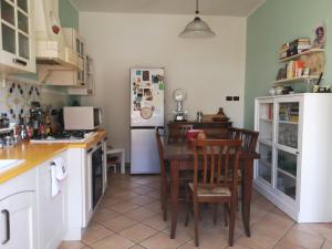 a kitchen with a table and a refrigerator at Stanza Il melo in fiore in Ferrara