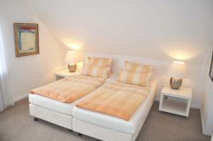 ein Schlafzimmer mit einem großen Bett mit zwei Nachttischen in der Unterkunft Gästehaus Steinhardt Appartement Nr 04 in Timmendorfer Strand