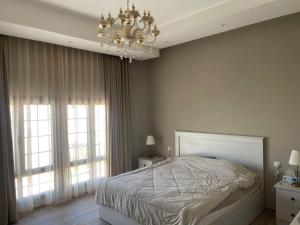 Un dormitorio con una cama grande y una lámpara de araña. en Holiday Stay Oman, en Salalah