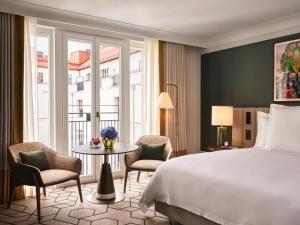 um quarto de hotel com uma cama, uma mesa e cadeiras em Rosewood Munich em Munique