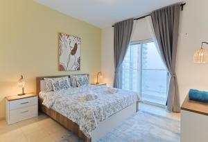 a bedroom with a bed and a large window at EliteRetreat - SeaView - Gym & Pool Access - Reem Island in Abu Dhabi