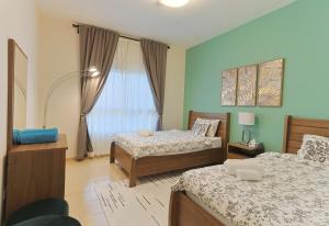 a bedroom with two beds and a window at EliteRetreat - SeaView - Gym & Pool Access - Reem Island in Abu Dhabi