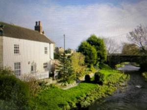 een huis met een rivier naast een gebouw bij Clearwater 17th Century Cottage in Richmond