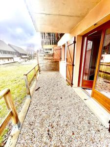 a walkway leading to a building with a porch at Super Besse chez Sophie 2ch, séjour, wifi, 2tv, rdc, terrasse, parc, piscine, pkg in Besse-et-Saint-Anastaise