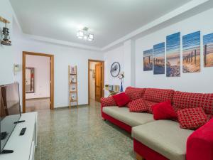 a living room with a red couch and a tv at Bluebeach in Las Palmas de Gran Canaria