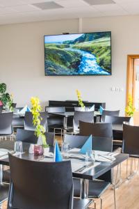 - un restaurant avec des tables et des chaises et une télévision murale dans l'établissement Hótel Laugar, à Laugar