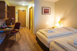 una camera d'albergo con due letti e una scrivania di Hótel Laugar a Laugar