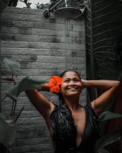 a woman with a flower on her head in the rain at Tongo Hill Cottages in Moalboal