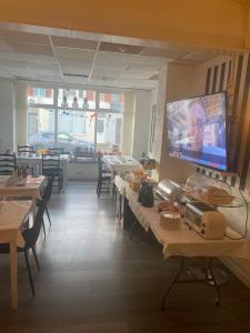 a restaurant with tables and a flat screen tv on the wall at The Cosy Nook in Blackpool
