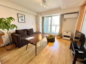 a living room with a couch and a table at AMSタワー中島 in Sapporo