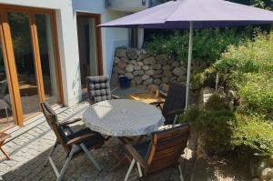 einen Tisch und Stühle mit Sonnenschirm auf einer Terrasse in der Unterkunft Haus am Strand Ferienwohnung Nr 01 in Niendorf