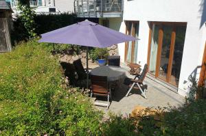 einen Tisch und Stühle unter einem Sonnenschirm in einem Garten in der Unterkunft Haus am Strand Ferienwohnung Nr 01 in Niendorf