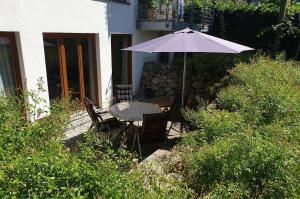 einen Tisch und Stühle mit Sonnenschirm in einem Garten in der Unterkunft Haus am Strand Ferienwohnung Nr 01 in Niendorf