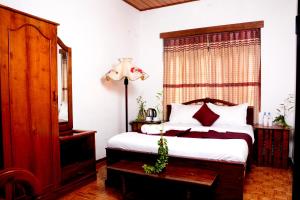 een slaapkamer met een groot bed en een raam bij The West Gate Bungalow in Nuwara Eliya