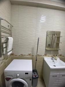 a bathroom with a washing machine and a sink at Atlantis in Bishkek