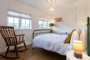 a bedroom with a bed and a chair at Peaceful Cottage by the Sea in Norwich