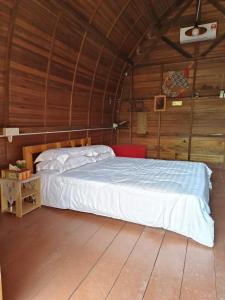 ein Schlafzimmer mit einem Bett in einer Holzhütte in der Unterkunft LBA chalet in Balik Pulau