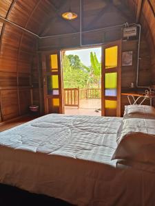 ein großes Bett in einem Zimmer mit offener Tür in der Unterkunft LBA chalet in Balik Pulau
