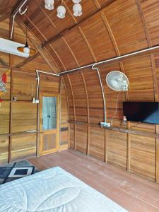 a bedroom with a bed in a wooden room at LBA chalet in Balik Pulau