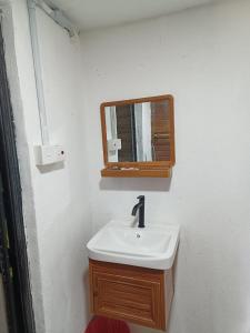 a bathroom with a sink and a mirror at LBA chalet in Balik Pulau