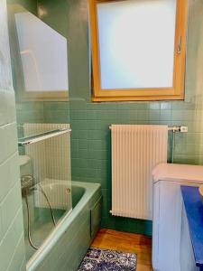 a green bathroom with a tub and a toilet at Walter's Haus - Maisonette au coeur de l'alsace in Hangenbieten
