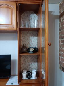 un armario de madera con tazas y platos. en Mirador de Bergosa, en Castiello de Jaca