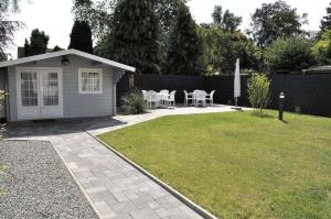 - un jardin avec un petit hangar, une table et des chaises dans l'établissement Haus Seehase Ferienwohnung Nr 03, à Haffkrug