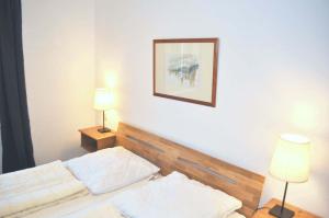 um quarto com uma cama com dois candeeiros e uma imagem na parede em Haus Windrose Ferienwohnung Nr 01 em Niendorf
