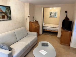 ein Wohnzimmer mit einem Sofa und einem Bett in der Unterkunft Haus Dulshorn Bremen in Bremen