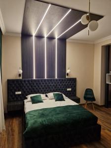 1 dormitorio con 1 cama grande con sábanas verdes en Bizi House Accommodation, en Drobeta-Turnu Severin