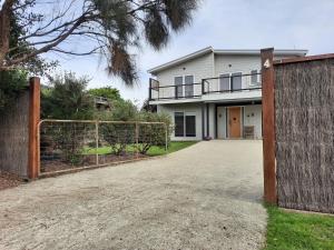 a house with a gate in front of it at Surfside Escape in Surf Beach