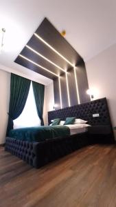 1 dormitorio con 1 cama grande y cabecero negro en Bizi House Accommodation, en Drobeta-Turnu Severin