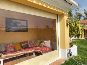 a couch sitting in a window of a house at 2Bedroom house with Swimming Pool and View in Moçarria